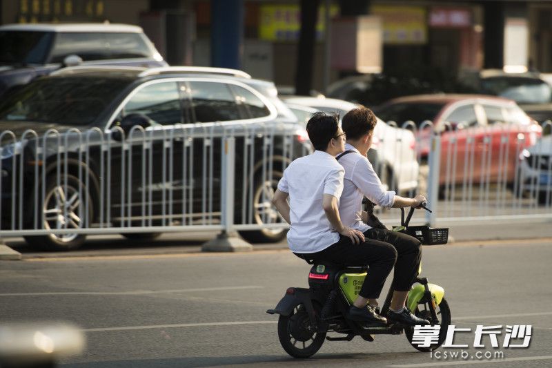 共享电单车违规载人，存在安全隐患，属于交通违法行为。长沙晚报全媒体记者 黄启晴 摄